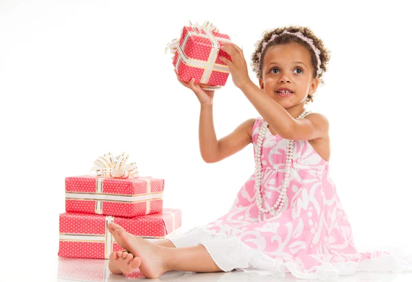 Little beautiful mulatto girl with gifts. — Stock Photo, Image