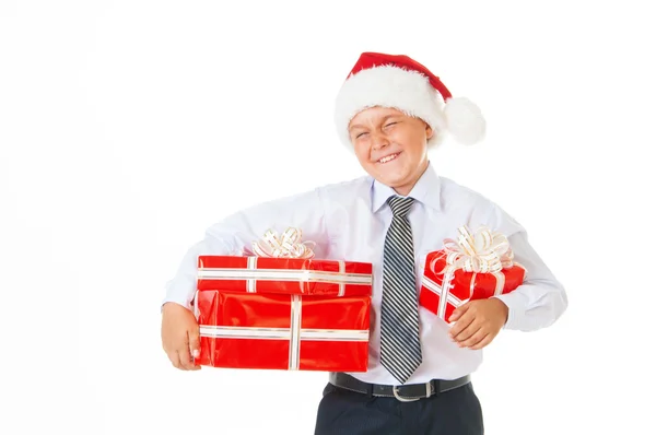 Menino feliz em um chapéu de Natal com presentes . — Fotografia de Stock
