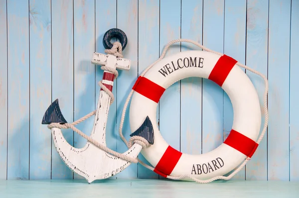 Anchor and life buoy on a background of white shabby wall boards. — Stock Photo, Image
