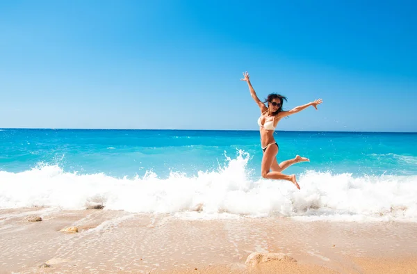 Cute brunette woman jump at sea — Stock Photo, Image