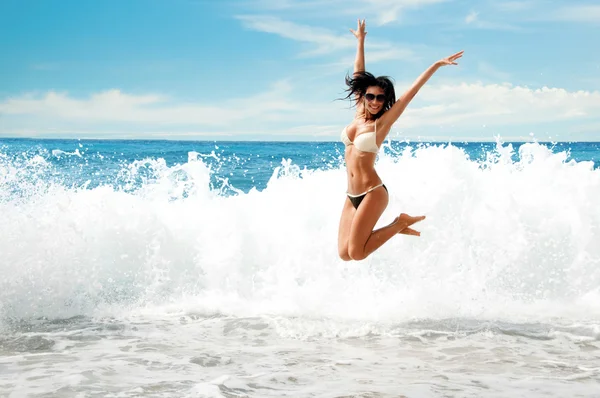 Hermosa joven saltando en el mar — Foto de Stock