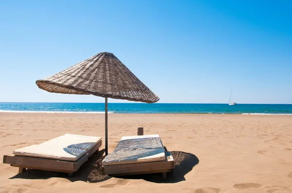 Лежаки и зонтики из ротанга на песчаном побережье . — стоковое фото