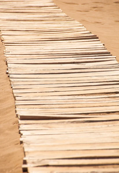 Gamla träbro på den sandiga stranden — Stockfoto