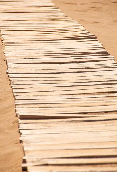 Oude houten brug over de zandige kust — Stockfoto