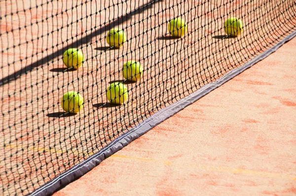 Tennisbälle auf dem Platz in der Nähe von Tennisnetzen — Stockfoto