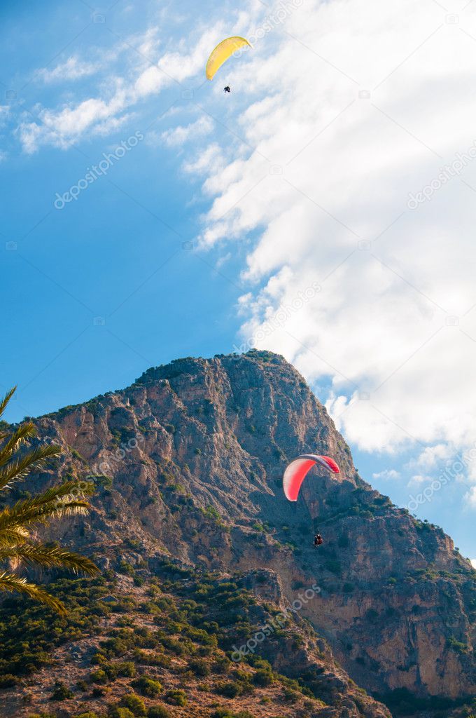 Parachute soaring in the clouds on a background of sky and mountains