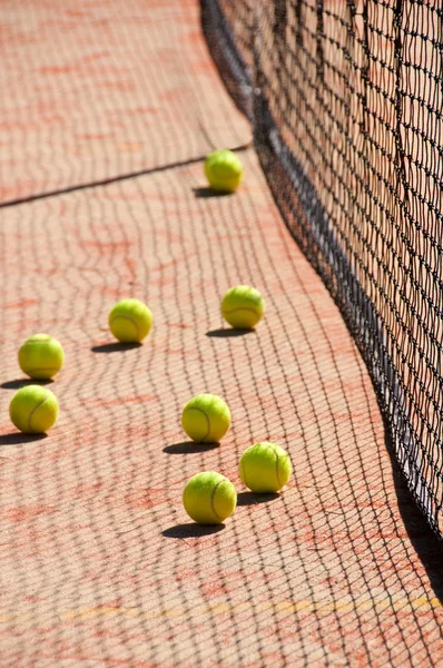 Tennisbälle auf dem Platz in der Nähe von Tennisnetzen — Stockfoto
