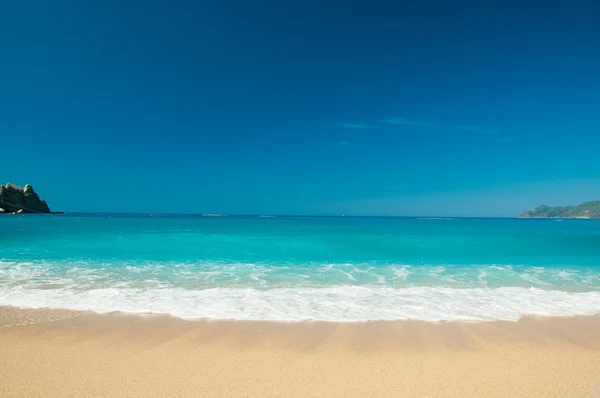 Beautiful surf on the beach. Mountains on the horizon. — Stock Photo, Image