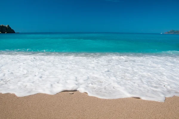 Vackra surf på stranden. berg vid horisonten. — Stockfoto