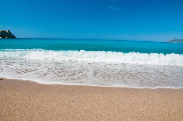 Vackra surf på stranden. berg vid horisonten. — Stockfoto