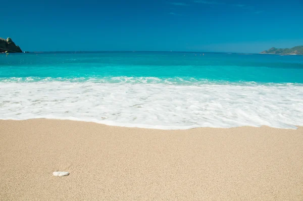 Vackra surf på stranden. berg vid horisonten. — Stockfoto