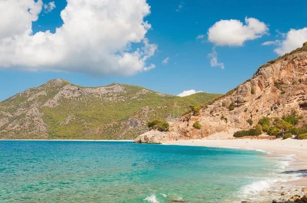 Vackra surf på stranden. berg vid horisonten. — Stockfoto