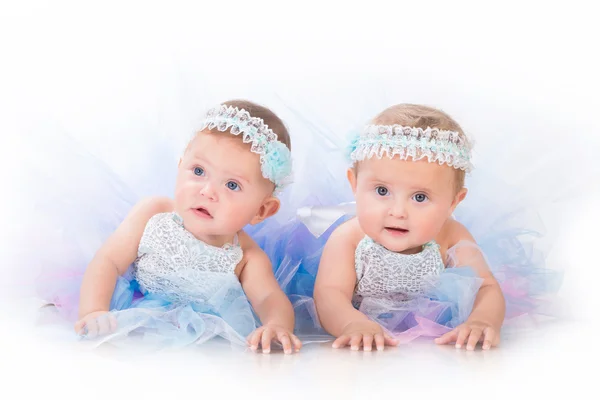 Две очаровательные сестры, маленькие близнецы в пышных красивых платьях — стоковое фото