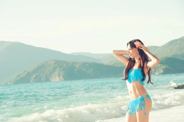 Slim beautiful woman on the sea coast looking  into distance — Stock Photo, Image