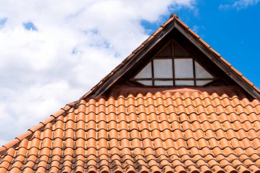 Mavi gökyüzüne karşı kahverengi kiremitli bir çatının yakın çekim görüntüsü. Yüksek kalite fotoğraf