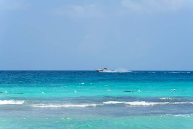 Deniz Burnu. Turkuaz deniz ve açık mavi gökyüzü. Ufukta bir tekne koşuşturuyor. Yüksek kalite fotoğraf
