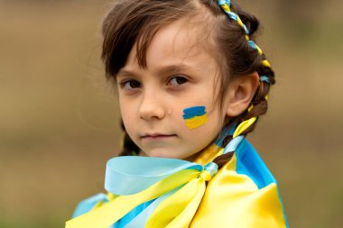Ukrayna bayrağı gibi sarı ve mavi kurdeleli iki örgülü güzel Ukraynalı kızın yakın plan portresi. Ukrayna 'yı kurtarmak için yardım istiyor. Savaşı durdurun. Yüksek kalite fotoğraf