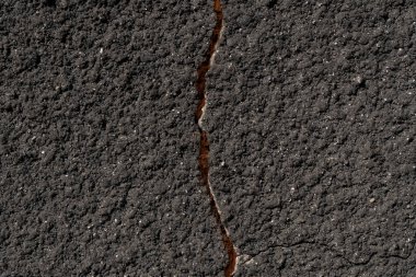 Çatlak gri bir duvara yakın plan. Düz olmayan granüler kaplama ile pürüzlü alçı dokusu. Yüksek kalite fotoğraf