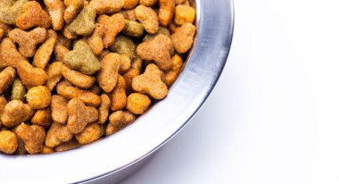 A close-up of part of a metal bowl with dry food for animals, cats and dogs. High quality photo