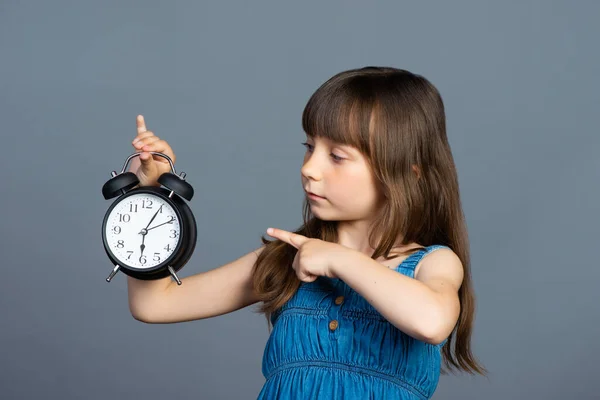 Ein Kleines Vorschulmädchen Hält Einen Runden Wecker Der Hand Und — Stockfoto