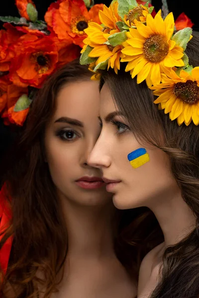 赤いケシの花の花輪とリボンで黄色のひまわりの2人の美しい女の子 概念ポーランドとウクライナ 友情とウクライナを助ける 戦争を止めなさい 高品質の写真 — ストック写真