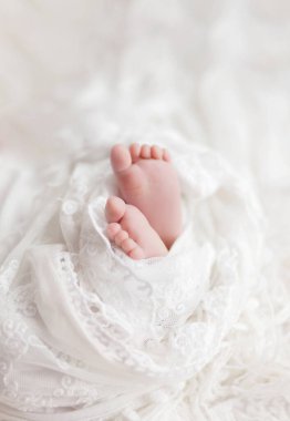 Bebeğin ayakları ılık, yumuşak bir battaniyeye sarılı, yeni doğmuş bebeğin ayakları ve ayak parmakları.