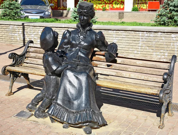 Escultura institutriz con un niño en un banco —  Fotos de Stock