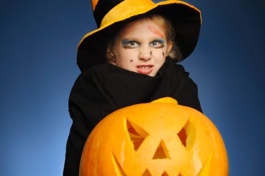 genç kız olarak bir cadı Halloween balkabağı ile.