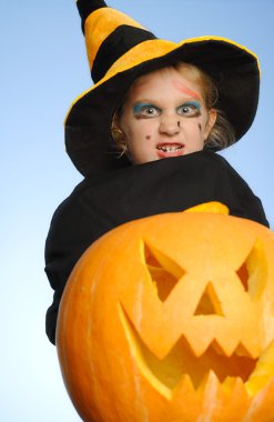 genç kız olarak bir cadı Halloween balkabağı ile.