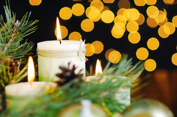 Bugigangas de Natal vermelho e vela no fundo preto de luzes douradas desfocadas . — Fotografia de Stock