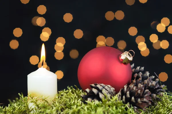 Röda julgranskulor och ljus på svart bakgrund av defocused gyllene ljus. — Stockfoto