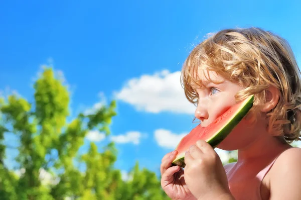 Lttle ragazza mangiare anguria sul cielo blu . — Foto Stock