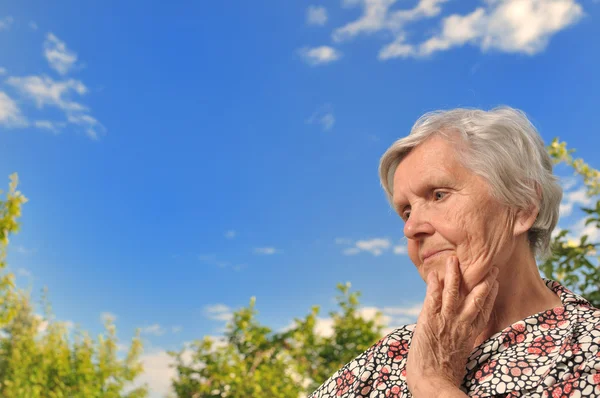 Seniorin - denken, draußen. — Stockfoto