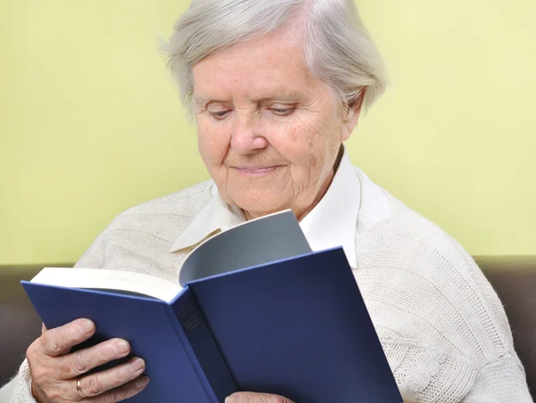Senior woman reading book in home. — Stock Photo, Image
