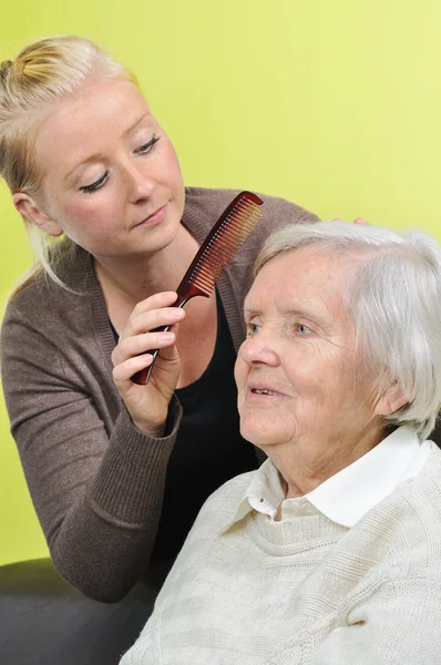 Äldre kvinna med hennes vårdgivare i hem. — Stockfoto
