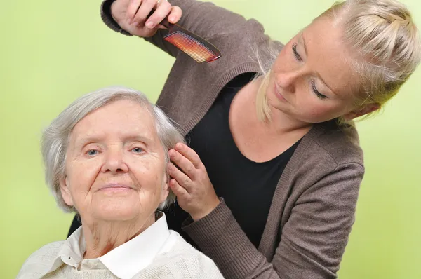Senior woman with her caregiver in home. — Stock Photo, Image