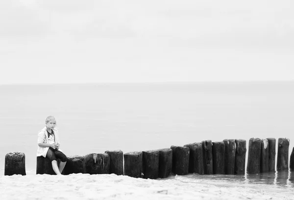 Liten flicka på stranden på havet bakgrund. — Stockfoto