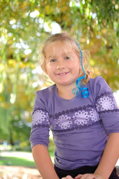 Kleines Mädchen spielt im Herbstpark, glückliches Kind. — Stockfoto