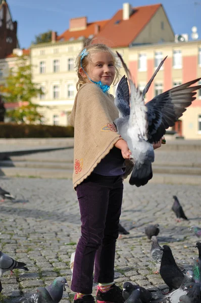 Petite fille nourrit colombes dans la ville . — Photo