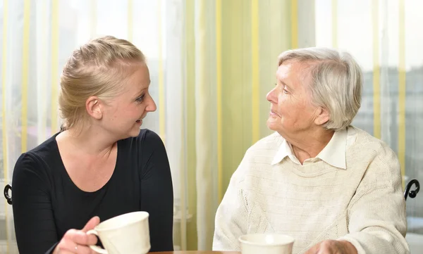 Mujer mayor con su nieta hablan entre sí . — Foto de Stock