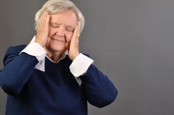 Senior mujer preocupada contra fondo gris . —  Fotos de Stock