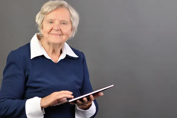 Seniorin mit Tablet glücklich. Stockbild