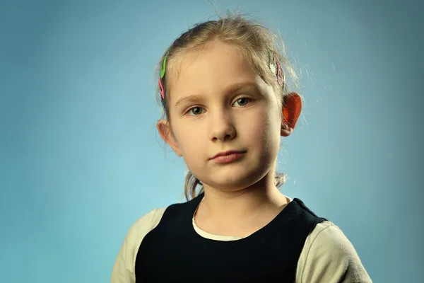 Portrait d'une petite fille sur fond bleu . — Photo