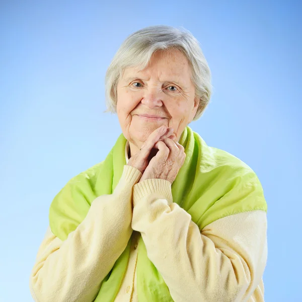Senior mulher feliz com cabelos grisalhos contra fundo azul . — Fotografia de Stock