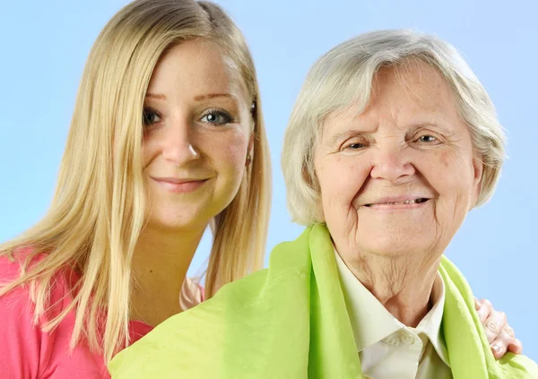 Child and grandchild give a gift senior woman. — Stock Photo, Image