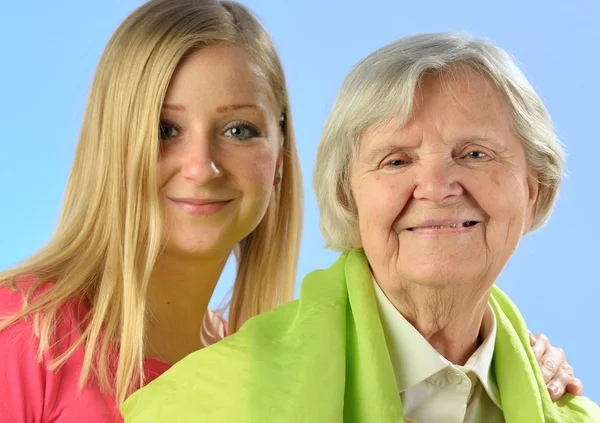 Child and grandchild give a gift senior woman. — Stock Photo, Image