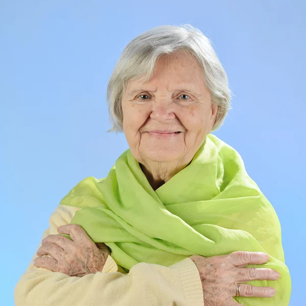 Senior glad kvinna med grå hårstrån mot blå bakgrund. — Stockfoto