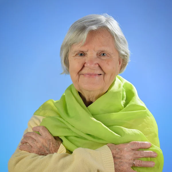 Senior mujer feliz con pelos grises sobre fondo azul . —  Fotos de Stock