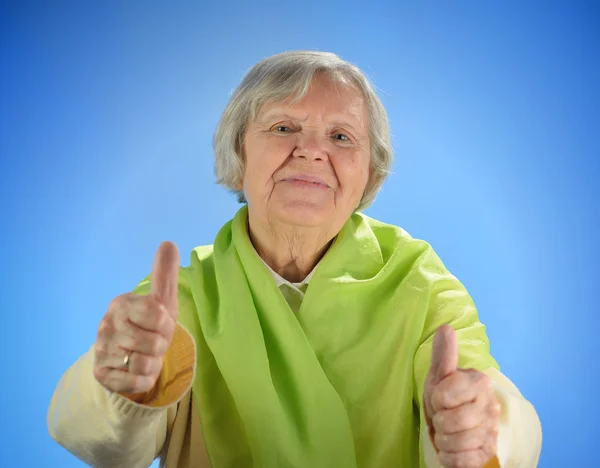 Senior happy woman with grey hairs against blue background. — Stock Photo, Image