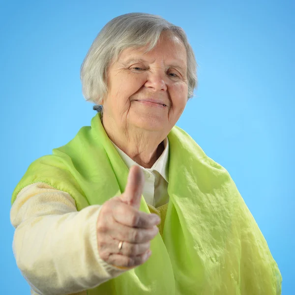 Senior gelukkig vrouw met grijze haren tegen blauwe achtergrond. — Stockfoto